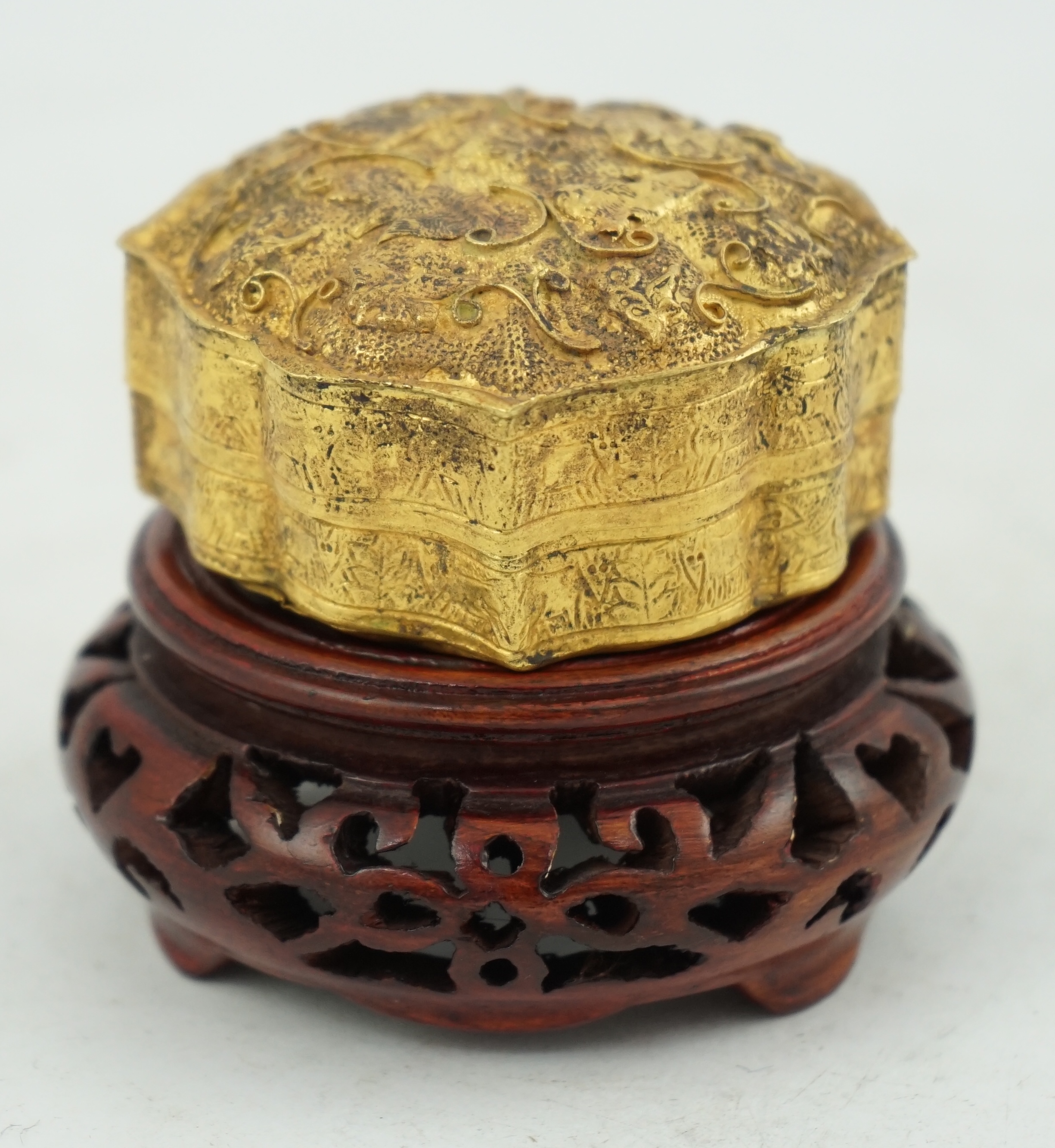 'An 18th century Chinese gilt repousee box & cover, probable Liao Dynasty', of petal lobed form, decorated with lions amid filigree scroll work, 5.5cm across